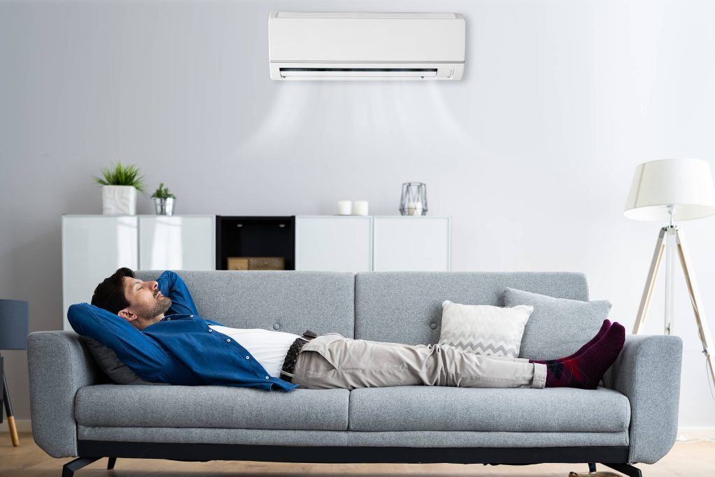 Man relaxing in an air conditioned living room